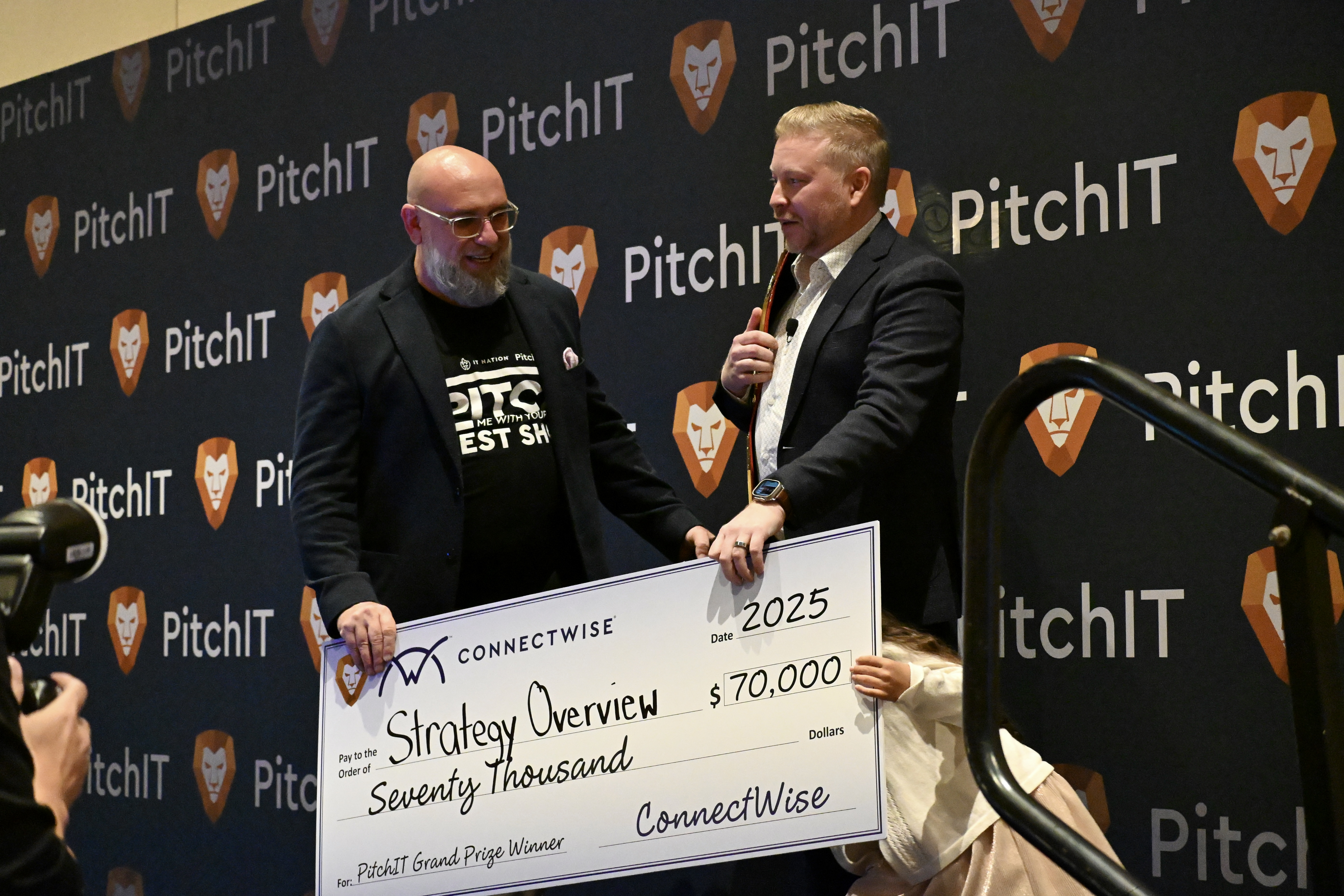 PitchIT presenter on stage speaking with cheque