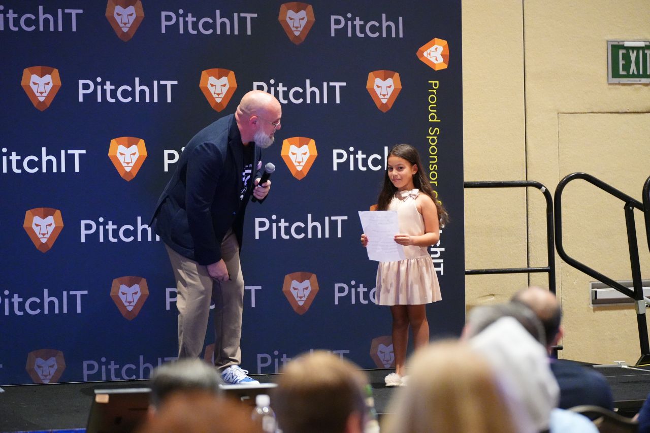 PitchIT presenter speaking with young participant on stage